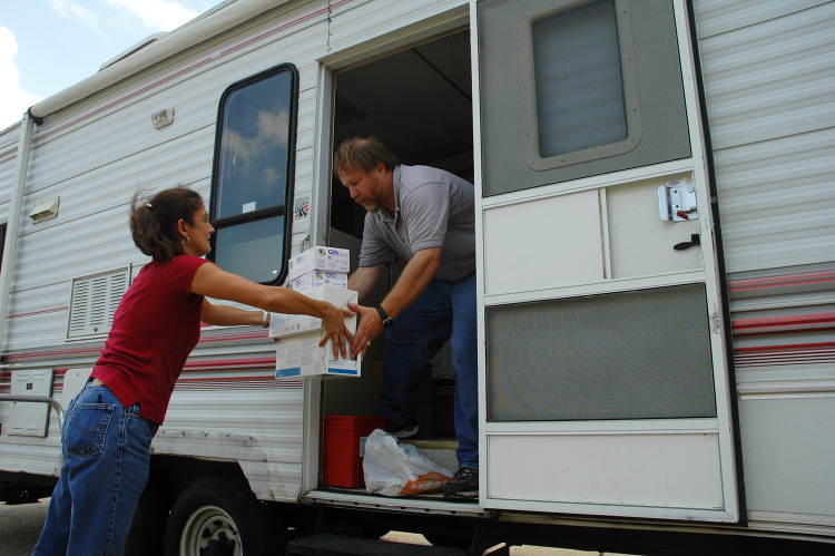 2 people loading supplies in a camper.